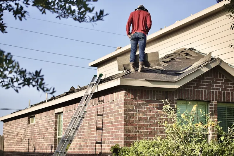 Professional roofer working on a residential roof in Okeana